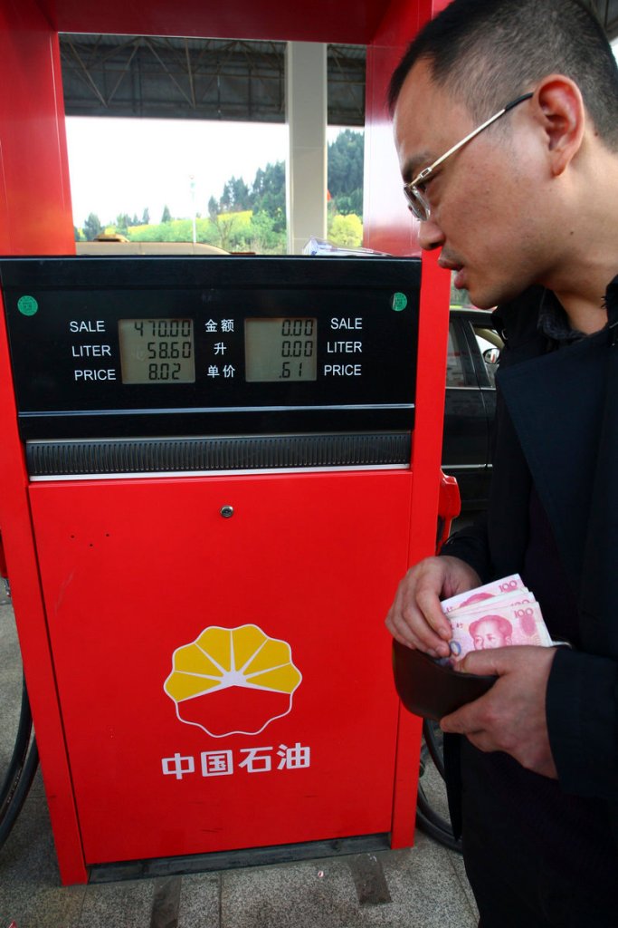 A customer in China’s southwestern province of Sichuan prepares to pay for gas at a PetroChina gas station this week. PetroChina is now pumping more oil than Exxon Mobil.