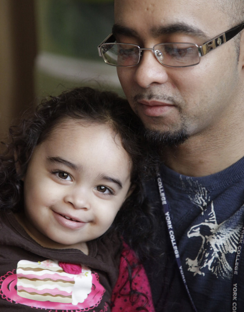 Cristina Astacio, 2, recently diagnosed with a mild form of autism, listens as her dad, Christopher Astacio, reads to her. Autism cases are reported on the rise again.