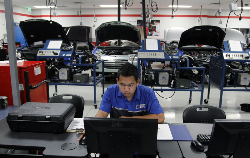 At the Universal Technical Institute in Irving, Texas, student Phalla Keo does research in his mechanic class. The industry is churning out technicians at the same time that warranty repairs are down and maintenance work is declining.