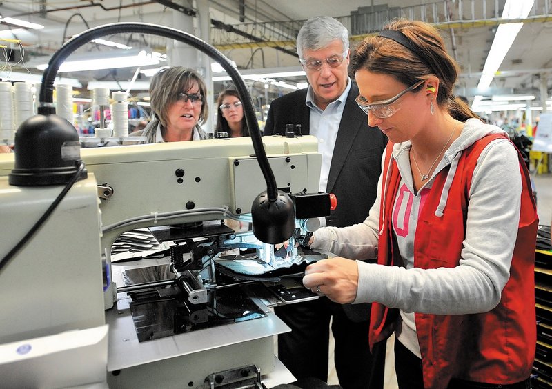 Rep. Mike Michaud, center, speaks with New Balance factory employee Tiffany Whitney on Friday morning in Norridgewock, where he toured the plant and picked up a pair of running shoes made for President Obama.