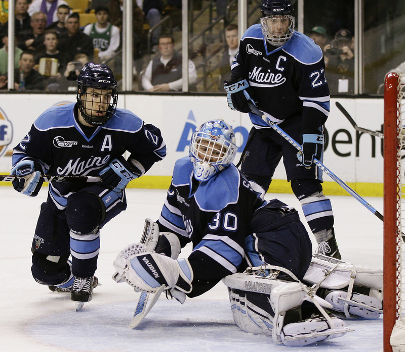 Maine goaltender Dan Sullivan and Stu Higgins, left, watch as a shot by Boston College’s Pat Mullane goes into the net for a second-period goal Saturday night during the Hockey East championship game in Boston. Boston College won, 4-1.