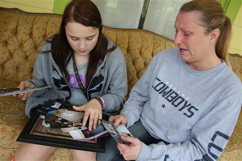 In this photo taken Tuesday, April 17, 2012, Kenneth Weishuhn's sister, Kayla Weishuhn, 16, and his mother, Jeannie Chambers, look at photos of Kenneth, 14, who committed suicide Sunday, April 15, 2012, at their home Primghar, Iowa. Chambers said she knew her son was being harassed but that she and the rest of the family didn't realize the extent of the bullying. (AP Photo/Sioux City Journal, Laura Wehde)