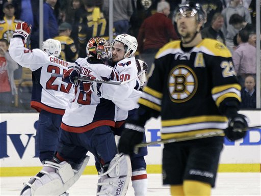 Boston Bruins center Chris Kelly skates away as Washington Capitals goalie Braden Holtby, center Marcus Johansson and left wing Jason Chimera celebrate the Capitals' 2-1 win in overtime in Game 7 of their first-round playoff series in Boston on Wednesday night.