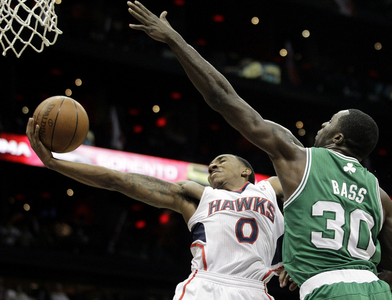 Atlanta Hawks' Jeff Teague, left, puts up a shot past Boston Celtics' Brandon Bass in Game 1 of the opening round of the playoffs Sunday in Atlanta.