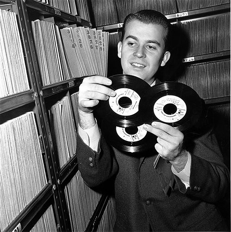 In this Feb. 3, 1959 file photo, Dick Clark selects a record in his station library in Philadelphia. Clark, the television host who helped bring rock `n' roll into the mainstream on "American Bandstand," died Wednesday, April 18, 2012 of a heart attack. He was 82. (AP Photo/File)