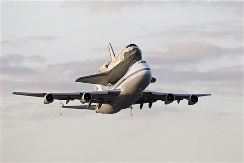 Space shuttle Discovery atop a 747 carrier jet departs the Kennedy Space Center, Tuesday, April 17, 2012, in Cape Canaveral, Fla. Discovery is being transported to the Smithsonian National Air and Space Museum in Washington. (AP Photo/John Raoux)