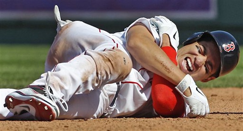 Boston Red Sox' Jacoby Ellsbury grabs his right shoulder after colliding with Tampa Bay Rays shortstop Reid Brignac while being forced at second base during the fourth inning of the home opening day baseball game at Fenway Park in Boston, Friday, April 13, 2012. (AP Photo/Charles Krupa)