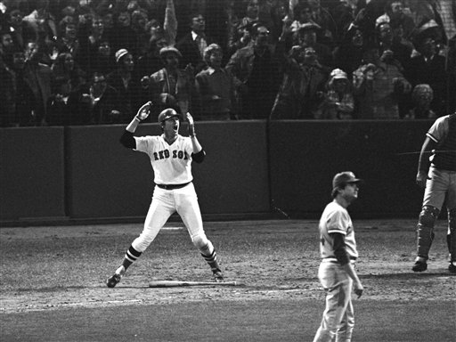 In this Oct. 22, 1975, photo, Boston Red Sox's Carlton Fisk, left, watches his 12th-inning home run against the Cincinnati Reds to win the sixth game of the World Series at Fenway Park in Boston.