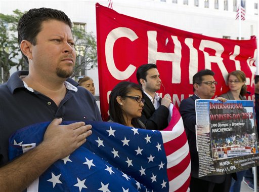 Raul Murrillo director of Hermandad Mexicana Nacional, left, joins the Coalition for Humane Immigrant Rights of Los Angeles during a vigil outside Los Angeles Federal court to denounce Arizona's immigration enforcement on Tuesday.