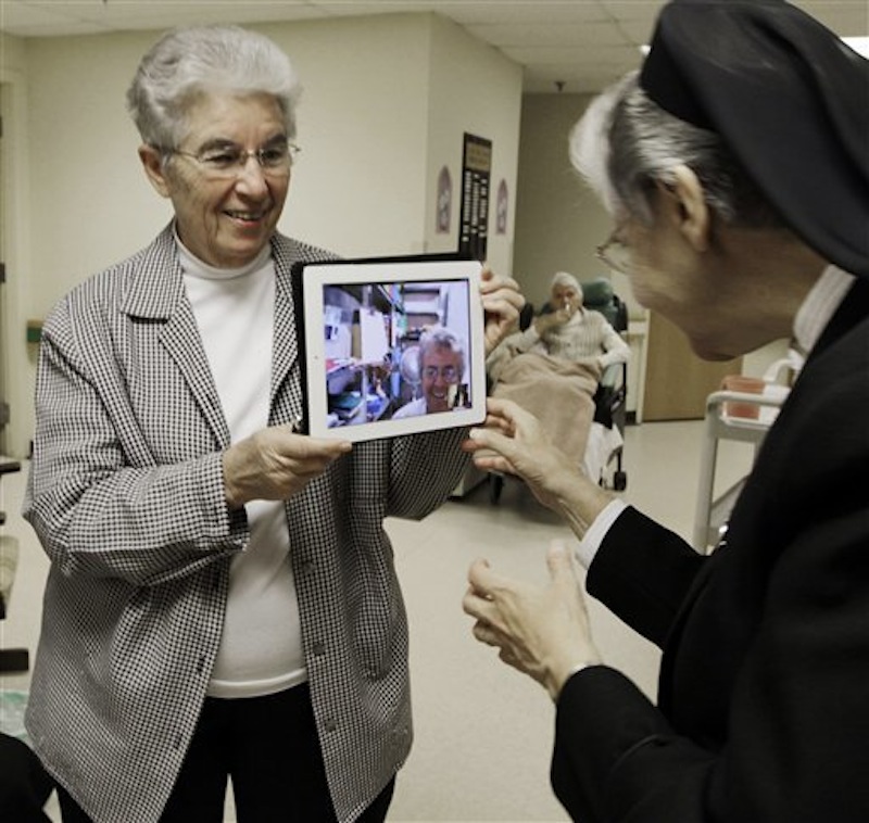 In this April 10, 2012 photo, sister Priscille Roy, left, holds up an iPad displaying her colleague, Sister Pauline Demers, who is in Brazil, to show Sister Elaine Lachance, right, at St. Joseph Convent in Biddeford, Maine. Good Shepherd Sisters of Quebec has just five convents in Maine and Massachusetts with fewer than 60 sisters. The youngest is 64, and itís been more than 20 years since a new member has joined. Sister Lachance is using the Internet, social media and even a blog to attract women who feel the calling to serve God. (AP Photo/Pat Wellenbach)