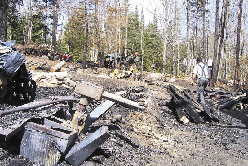 REMAINS: Donald Smiley Jr., 72, cleans up the charred remains of his family-owned sawmill, which was destroyed by a fire early Saturday morning. Smiley recently handed over the business he and his wife Pamela started 32 years ago to their son, Brian, who plans to rebuild the uninsured mill off Knowlton Corner Road.