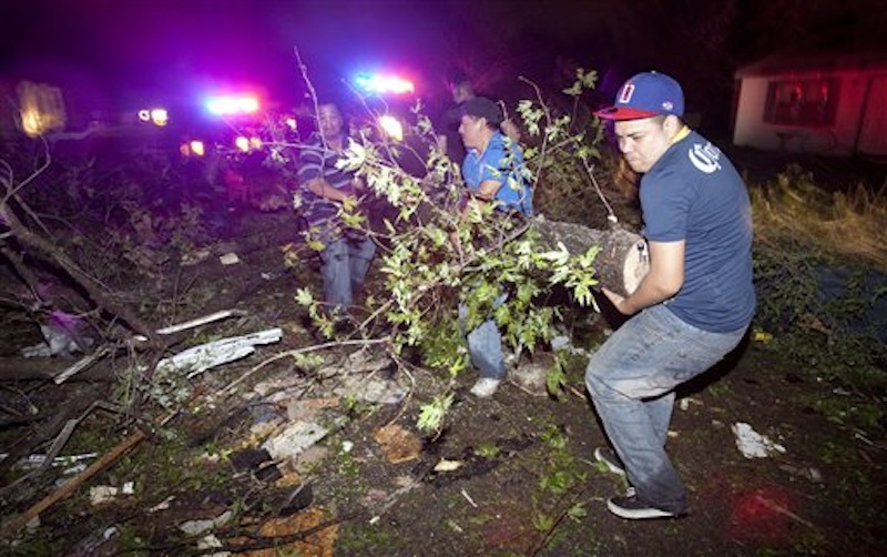 Residents of a south Wichita neighborhood clean up fallen trees after a tornado caused massive destruction in the Wichita, Kan.-area on Saturday night, April 14, 2012. (AP Photo/The Wichita Eagle, Travis Heying)