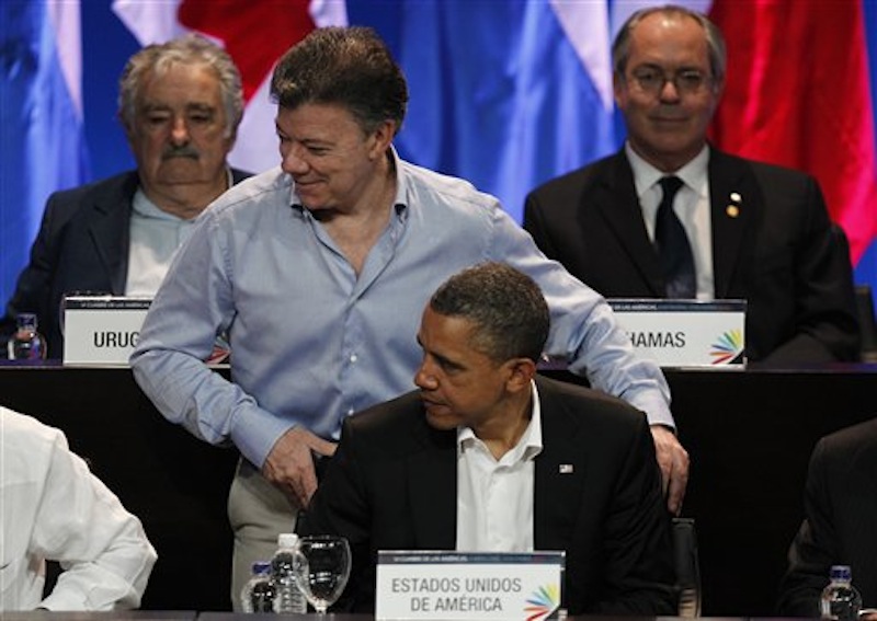 Colombia's President Juan Manuel Santos stands behind President Barack Obama at the opening ceremony of the sixth Summit of the Americas at the Convention Center in Cartagena, Colombia, Saturday April 14, 2012. The summit brings together presidents and prime ministers from Canada, the Caribbean, Latin America and the U.S. Back left is Uruguay's President Jose Mujica. (AP Photo/Fernando Vergara)
