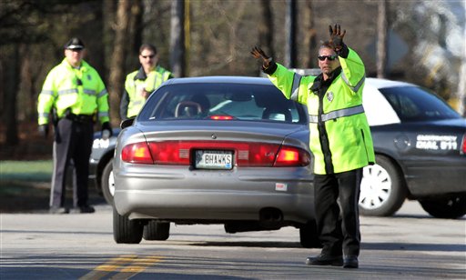 Police direct traffic at a roadblock, Friday, April 13, 2012 in Greenland, N.H. as they continue to investigate a shooting where five police officers were shot Thursday evening. Officials said Greenfield Police Chief Michael Maloney was killed, and four detectives from other departments were injured. A Maine woman, Brittany Tibbetts, was also killed, according to her mother. (AP Photo/Jim Cole)