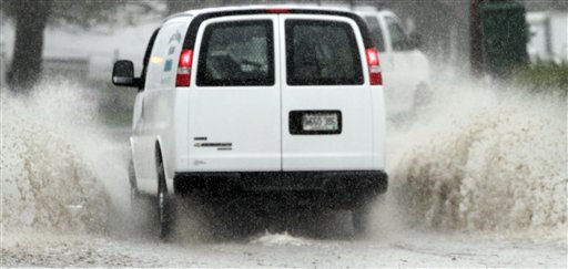 A vehicle navigates through a flooded street in Brunswick today as the state received its first major rain storm during April.
