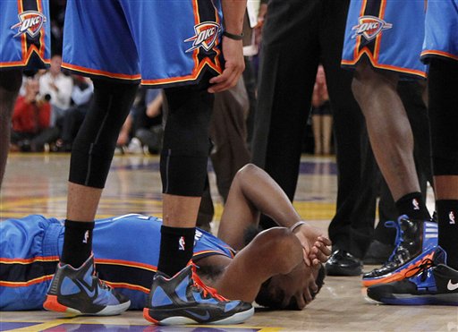 Oklahoma City Thunder players stand over teammate James Harden after he received a flagrant double foul from Los Angeles Lakers' Metta World Peace, who was then ejected. The incident took place in the first half of a game on Sunday in Los Angeles.