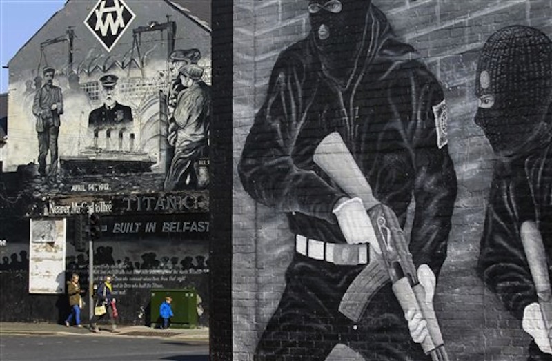 People walk past a Titanic mural in the Loyalist Newtownards Road area of East Belfast, Northern Ireland, Friday, April 13, 2012. (AP Photo/Peter Morrison)
