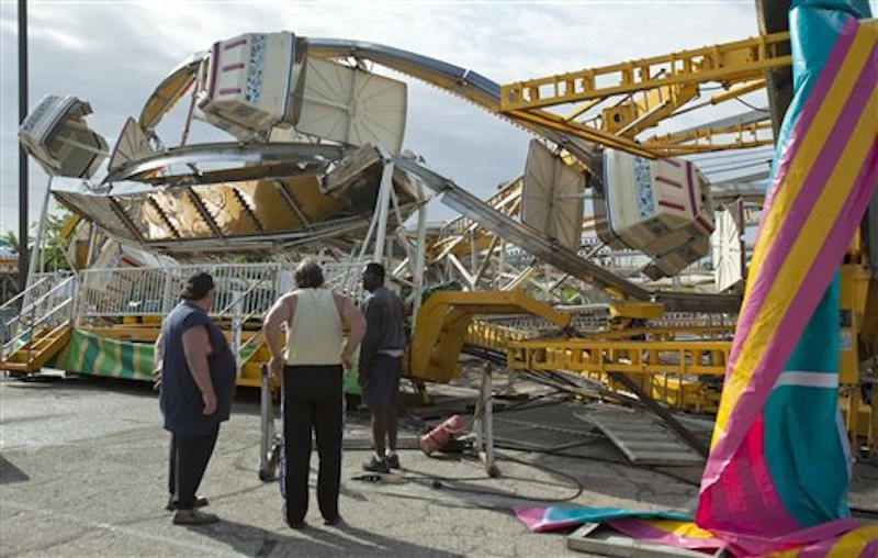Ottaway Amusement, Inc. workers survey the damage to a 65-foot tall Ferris wheel Sunday morning, April 15, 2012, that toppled over onto another ride at Kellogg and Greenwicht following a tornado that swept through east Wichita overnight Saturday. (AP Photo/The Wichita Eagle, Mike Hutmacher)