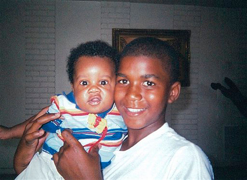 In this photo provided by the Martin family, Trayvon Martin holds an unidentified baby. Martin, 17 of Miami Springs, Fla., was killed by a neighborhood watchman following an altercation in Sanford, Fla. as he walked from a convenience store in February 2012. (AP Photo/Martin Family, File)