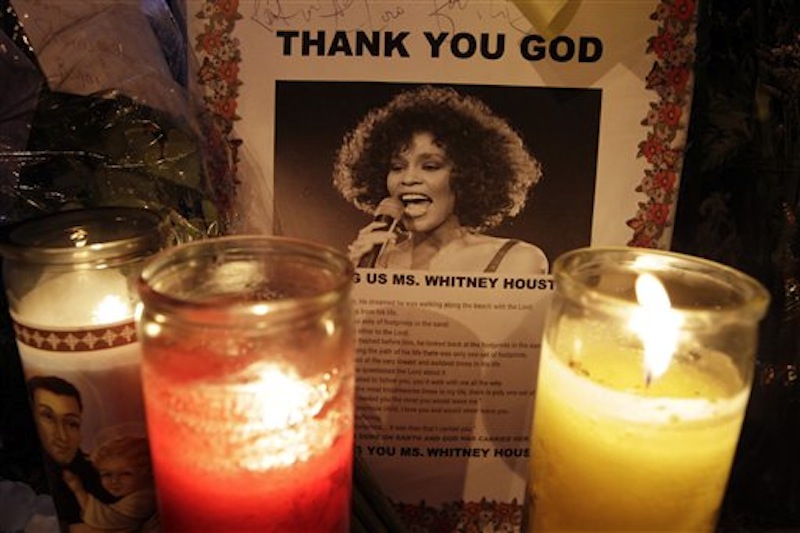 Candles burn at a memorial at a memorial to Whitney Houston outside New Hope Baptist Church in Newark, N.J., early Saturday, Feb. 18, 2012. (AP Photo/Mel Evans)