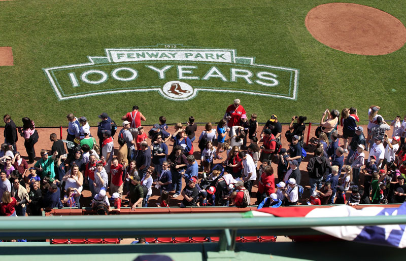 Lines of baseball fans make their way along the infield at Fenway Park in Boston today during an "open house" as part of the Boston Red Sox's celebration of the 100th anniversary of the first regular-season baseball game at the ballpark.