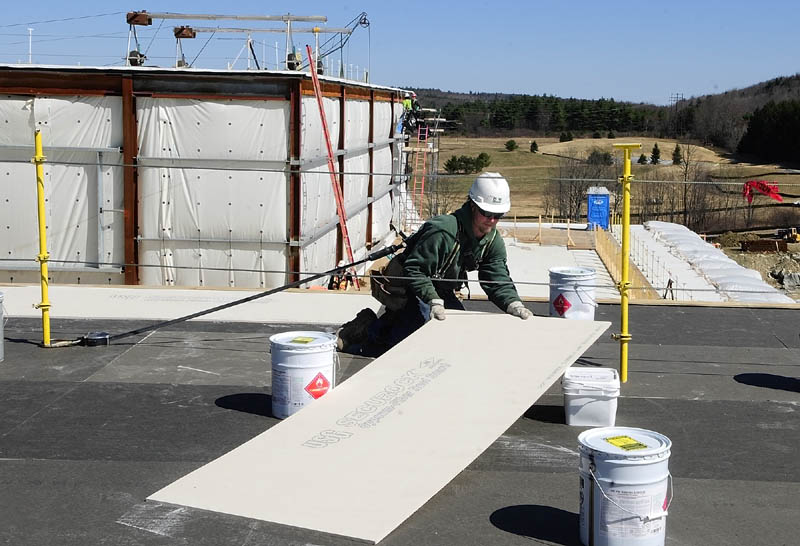 A G&E Roofing worker moves an insulation board into place last week at the new MaineGeneral regional hospital being built in Augusta.