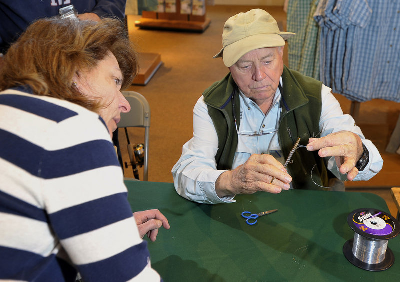 Lefty Kreh is quick to teach fishing intricacies, including showing Norma Nardone of Kennebunk how to tie a 6-loop clinch knot with forceps during a visit to L.L. Bean.