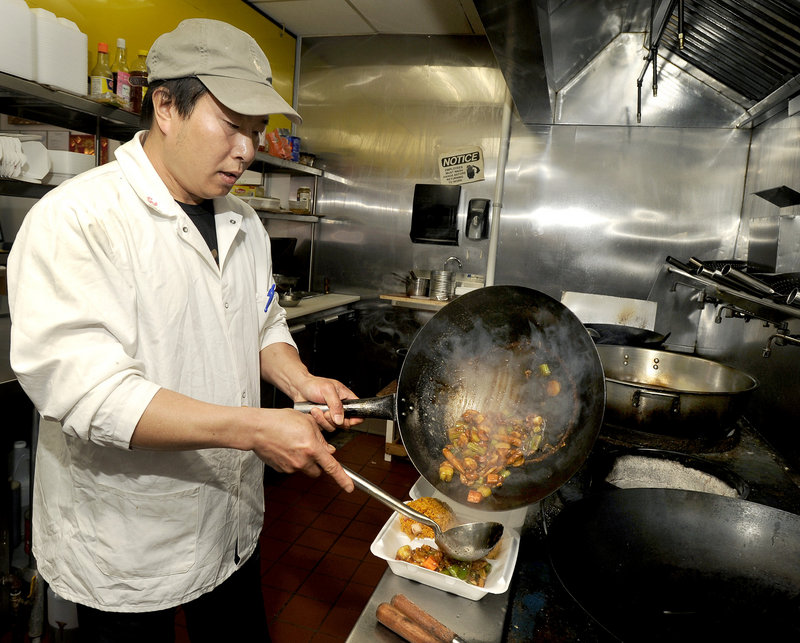 Guo Sen Shi, owner and cook at China Taste, serves up a meal of cashew chicken with mixed vegetables and pork fried rice.