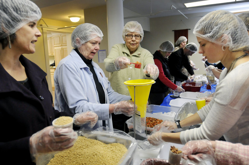 Volunteers package food assembly-line style Sunday at Trinity Lutheran Church in Westbrook, where their aim was to package 10,000 meals in about an hour as part of the Outreach Inc. Kids Care program. Volunteers, from left to right, are Janette Gustafson, Nancy Crump, Hazel Maloney and Abi Gustafson.