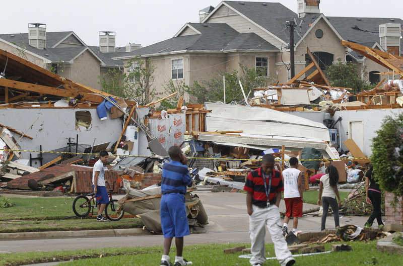 Neighbors view what remains of a home in Arlington, Texas. Preliminary estimates are that six to 12 tornadoes touched down in the north Texas area.