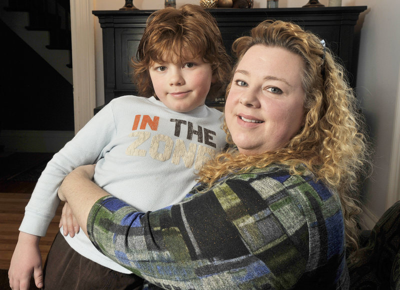 Ginger Taylor of Brunswick holds her 10-year-old son Chandler, who is autistic. “Now, we are going to throw millions of dollars away that have been spent on research and tracking to follow new criteria,” Taylor said.