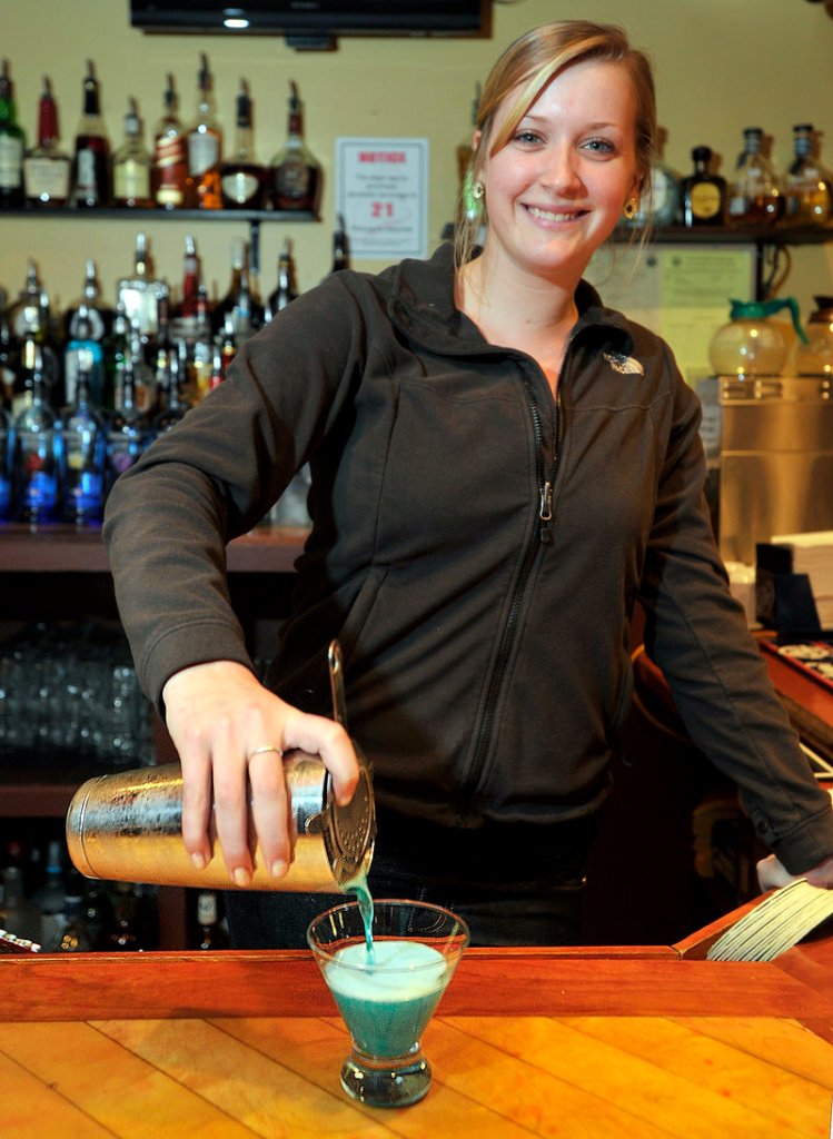 Bartender Sarah O’Neil makes a Blue Melon Martini, one of the Tuesday half-price specials at the Grill House Local Tavern in South Portland.