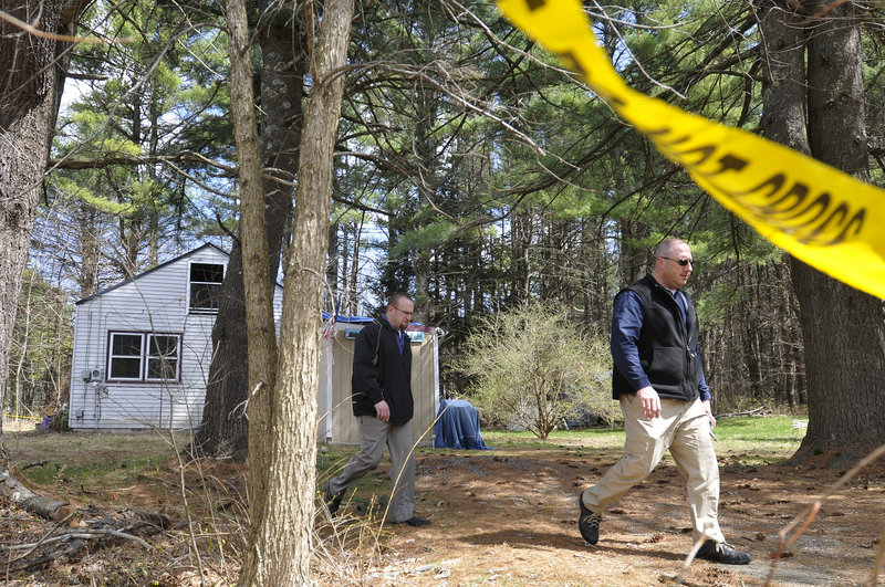 Gorham police detectives Sgt. Dana Thompson, right, and Brian Key leave the scene of a house fire early Wednesday on County Road. The cause was believed to be accidental.