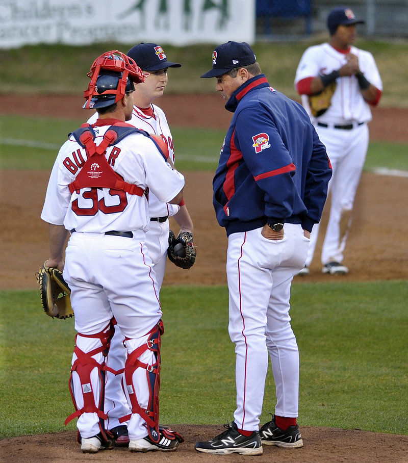 Ralph Treuel, the Sea Dogs’ pitching instructor, visits with pitcher Brock Huntzinger and catcher Dan Butler as Huntzinger struggled early in the game.
