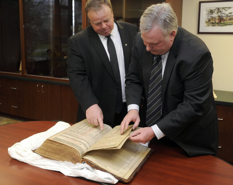 David Moyer, left, and Glenn Johnston look over a 400-year-old first edition of the King James Bible from the collection of the Maryland Bible Society in Stevenson, Md. The Bible bears the printer’s official dedication to the king.