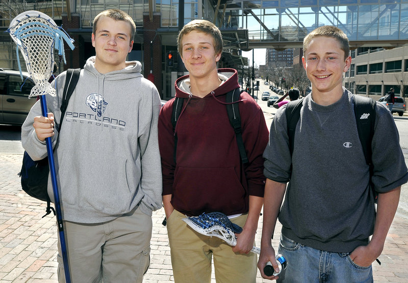 Stephen Walsh, 14, left, Ben Hagelin, 15, and Jack Carroll, 15, students at Portland High School, talk about the new regulations for teenage drivers before walking to lacrosse practice at Fitzpatrick Stadium on Friday.