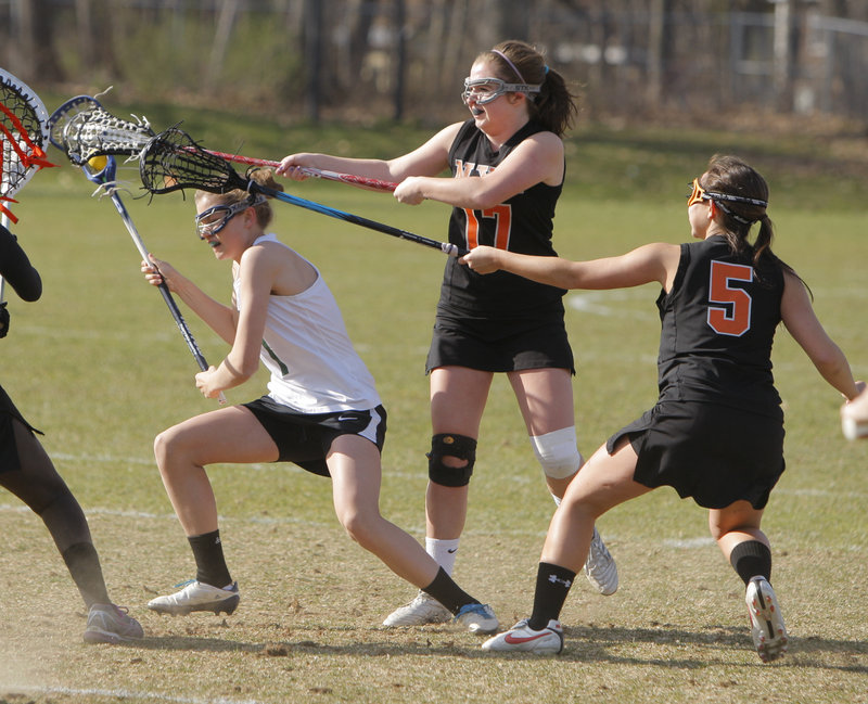 Walker Foehl, left, of Waynflete is pressured by North Yarmouth Academy’s Katie Cawley, center, and Hannah Twombly. Waynflete built a 14-1 halftime lead on the way to a 15-5 win.