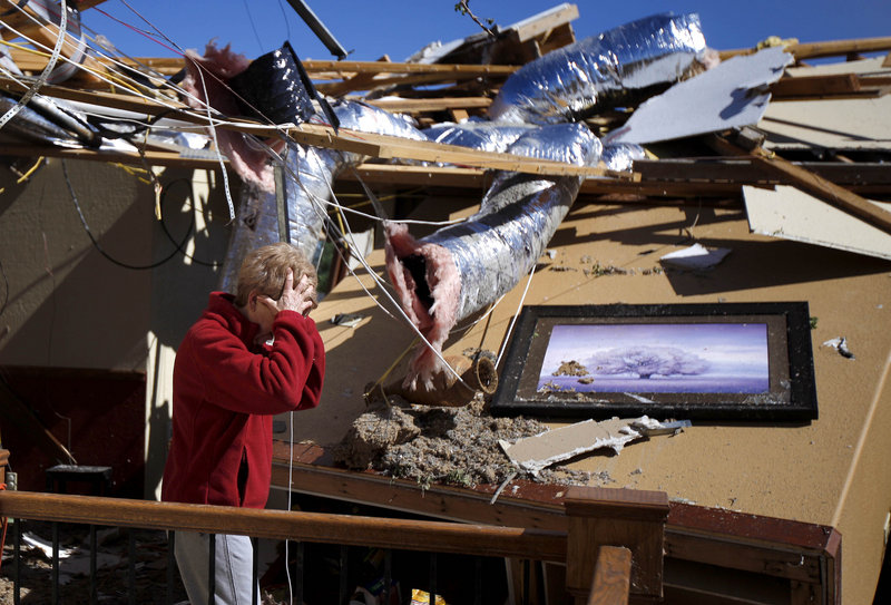 Carole Beckett reacts as she sorts through her belongings Sunday in Woodward, Okla., where five people died in Saturday’s tornado. Storms also struck in Kansas, Iowa and Nebraska, but there were no fatalities in those states – thanks to days of urgent warnings, residents and officials say.