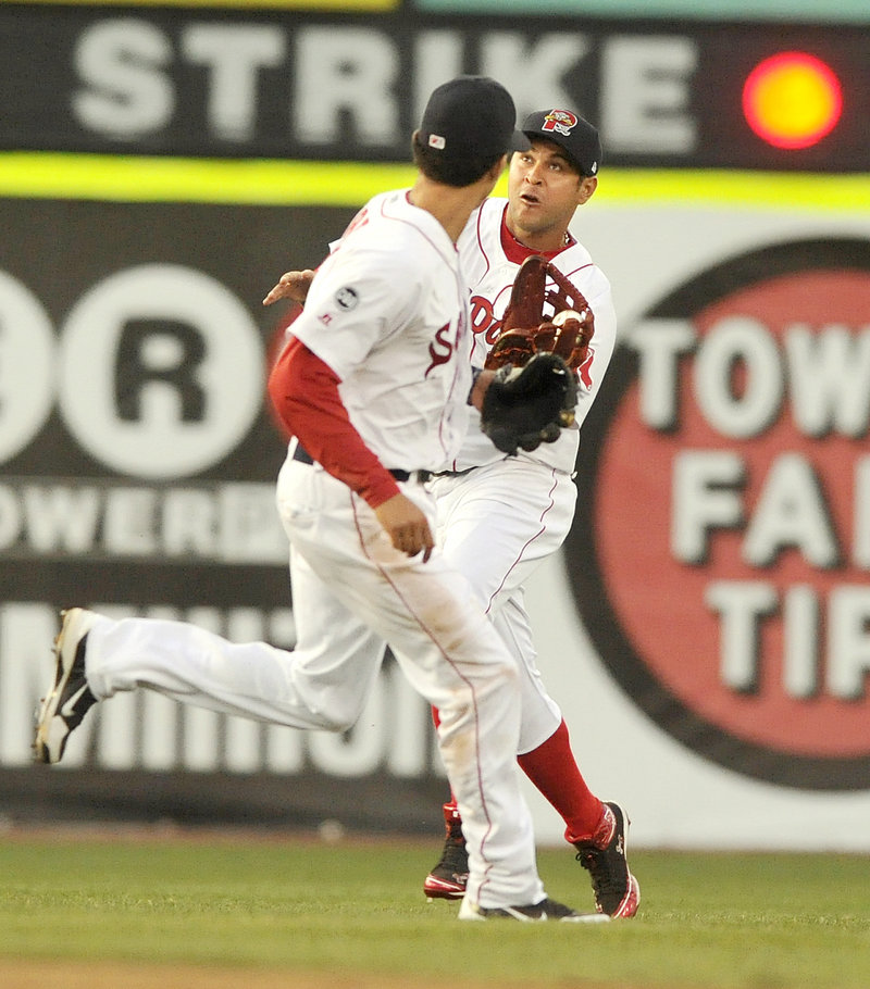 Center fielder Ronald Bermudez of the Portland Sea Dogs pulls in a shallow fly ball Monday night in front of teammate Derrick Gibson in the third inning. The Sea Dogs lost 10-5 to the New Britain Rock Cats in 11 innings.