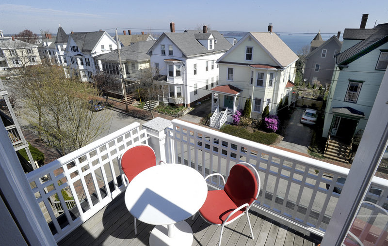 The third-floor balcony of the triple-decker on Munjoy Hill in Portland owned by Pamela Hawkes and Scott Teas boasts views of Casco Bay.
