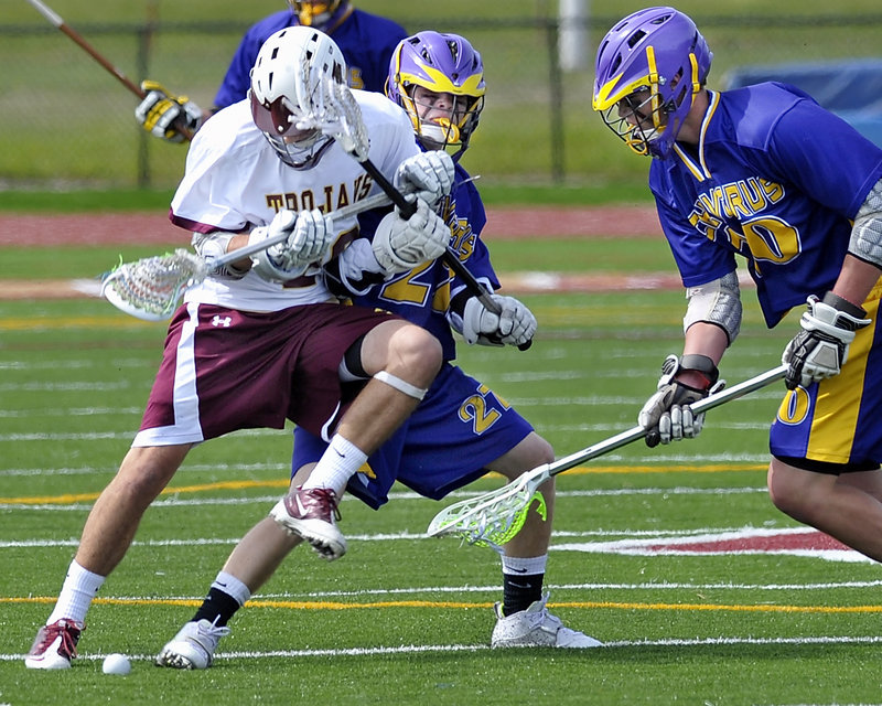 Josh Cyr, left, of Thornton Academy competes for the ball with Jack Sutton of Cheverus as Cam Olson of Cheverus comes in to scoop it up Wednesday. Cheverus recovered from a season-opening loss against Deering to beat the Trojans, 5-2.