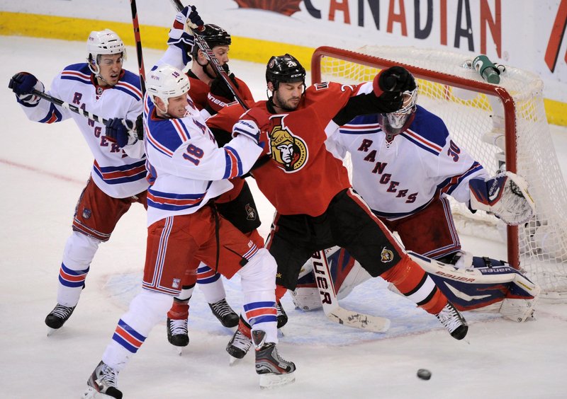 Zenon Konopka of Ottawa battles for position in front of Rangers goalie Henrik Lundqvist while tangling with New York’s Marc Staal in Wednesday’s game at Ottawa. The Senators won 3-2 in overtime to tie the series, 2-2.