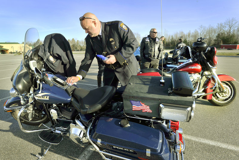 Detective Ray Williams of the Windham Police Department polishes his motorcycle before joining the procession.