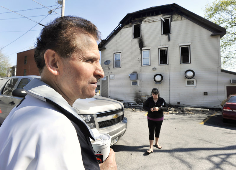 Owner Angelo Sotiropoulos surveys the damage to the downtown building housing the Gorham House of Pizza on Friday.