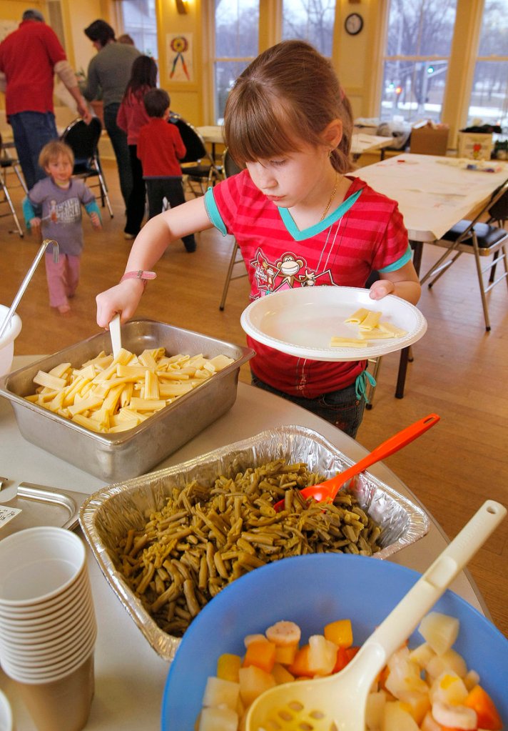 Jenna Buzzell scoops pasta onto her plate in 2008 at the weekly Parkside Supper Club, a dinner program, held at Portland’s Parkside Community Center, designed to help build community. This is a good time of year to begin to forge closer bonds with people who live in the neighborhood, a reader says.