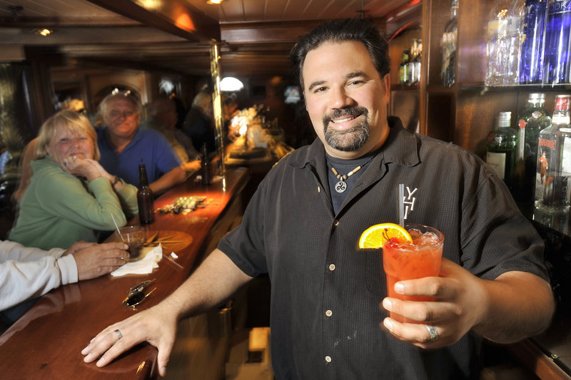 Mike Fitzgerald, bartender at the Ship’s Cellar Pub at the York Harbor Inn, serves a YHI Trio, a rum-punch specialty drink popular at the bar.