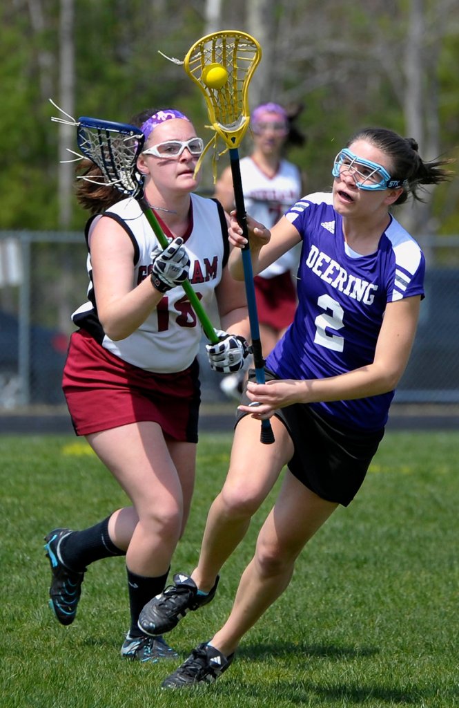 Delaney Loring, right, of Deering attempts to keep the ball in the basket as Ashley Gaudette of Gorham looks to knock it out during the first half.