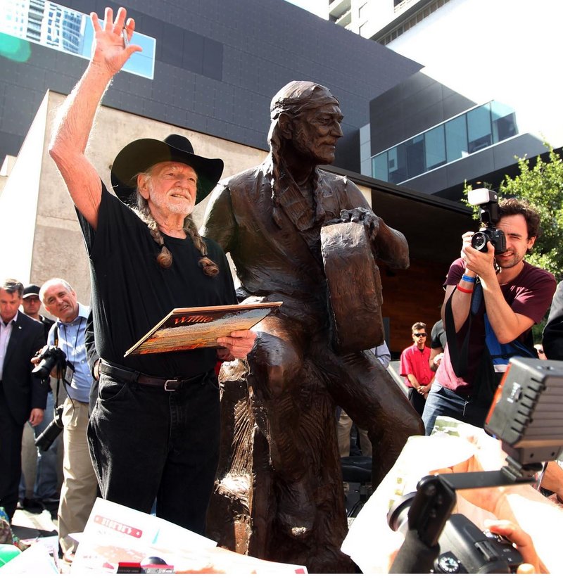 Country singer Willie Nelson waves at the unveiling of an 8-foot-tall statue of himself Friday in Austin, Texas. He also performed with his sister Bobbie Nelson.
