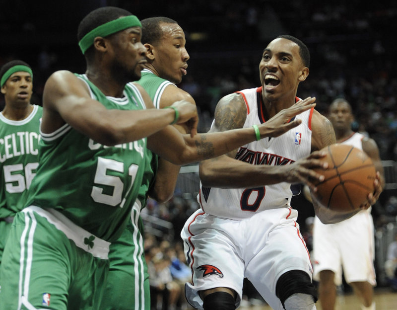 Atlanta’s Jeff Teague is defended by Boston’s Keyon Dooling (51) and guard Avery Bradley during the first half of Friday’s 97-92 win for the Hawks. The Celtics fielded an unusual lineup after playing 11 games in 15 days.