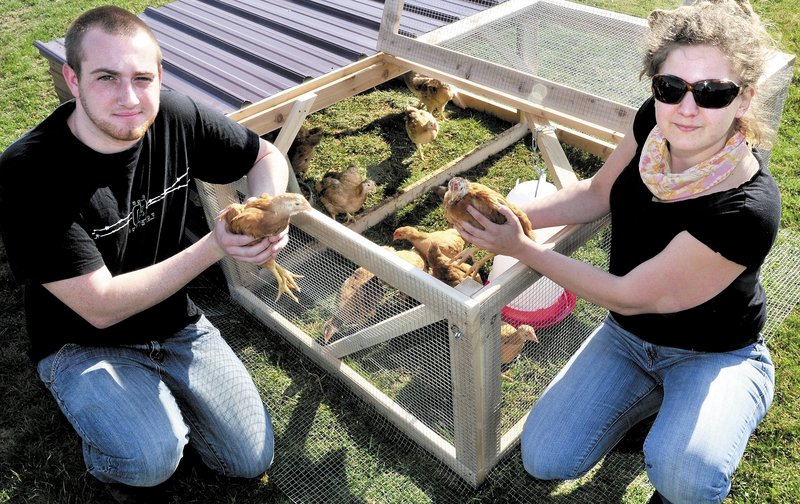 Unity College student Shayne Van Leer and food and farm projects coordinator Sara Trunzo show off broiler chicks.